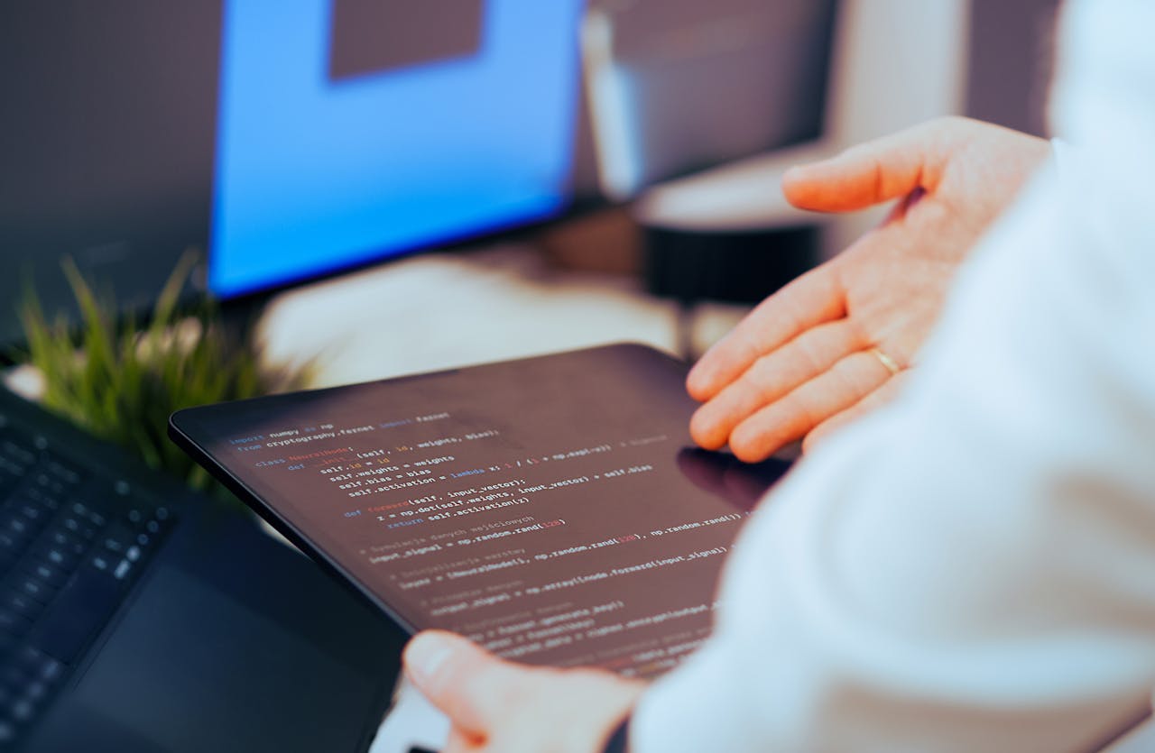 pexels photo 36598855 Software developer analyzing code on a tablet in a modern office workspace.